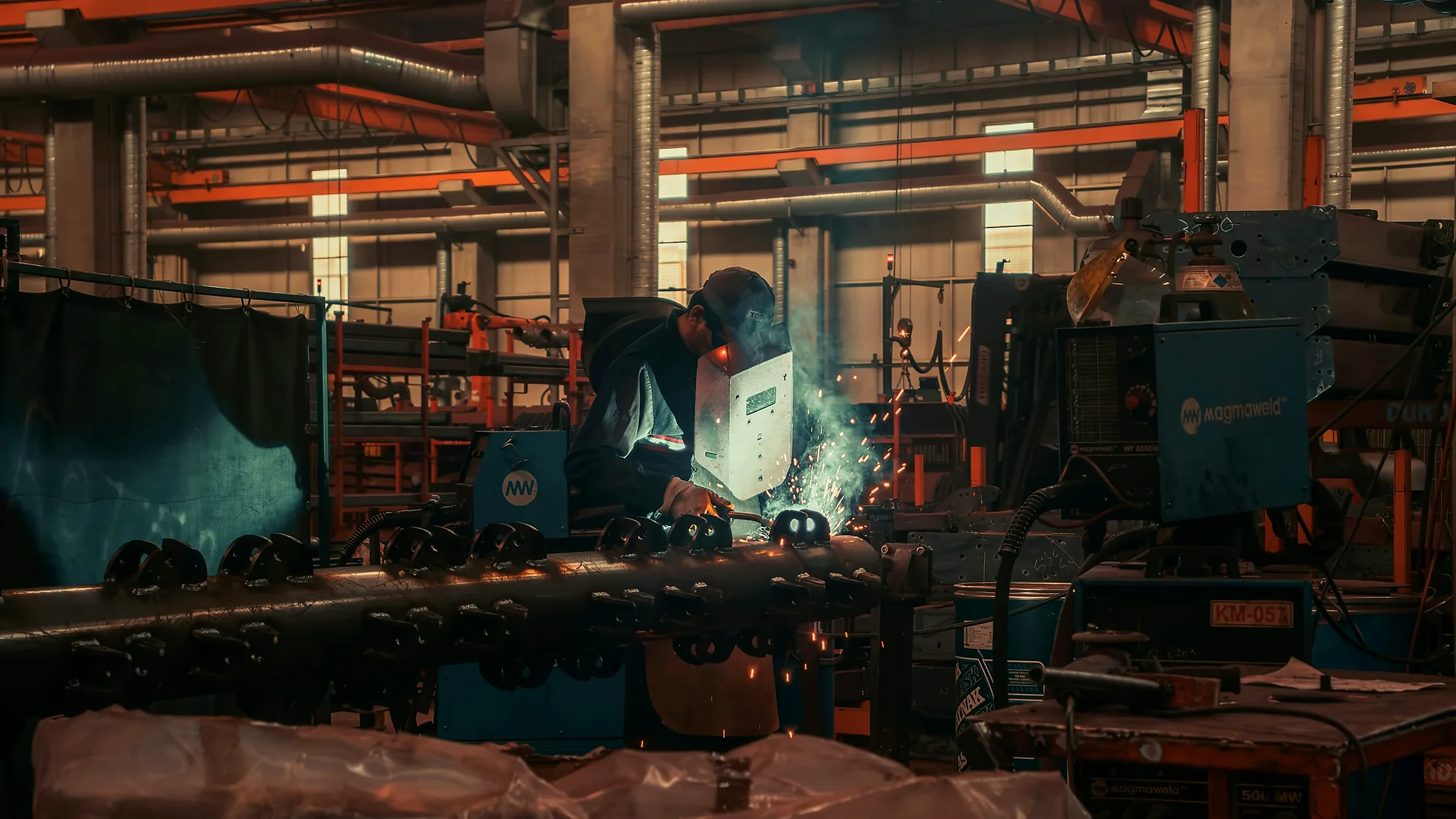 Person welding metal in an industrial workshop.